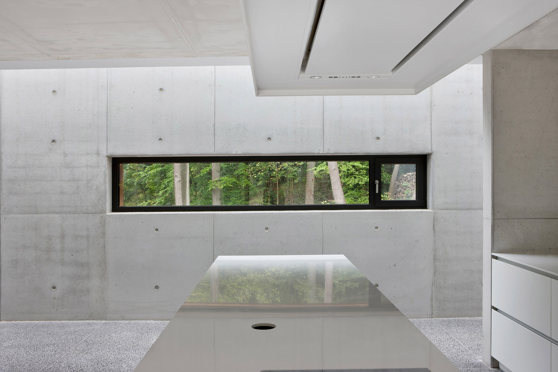 Pohledový beton je dominantním prvkem interiérového designu. Vidět je z části otvíravý okenní element ze systému Schüco AWS 75.SI.