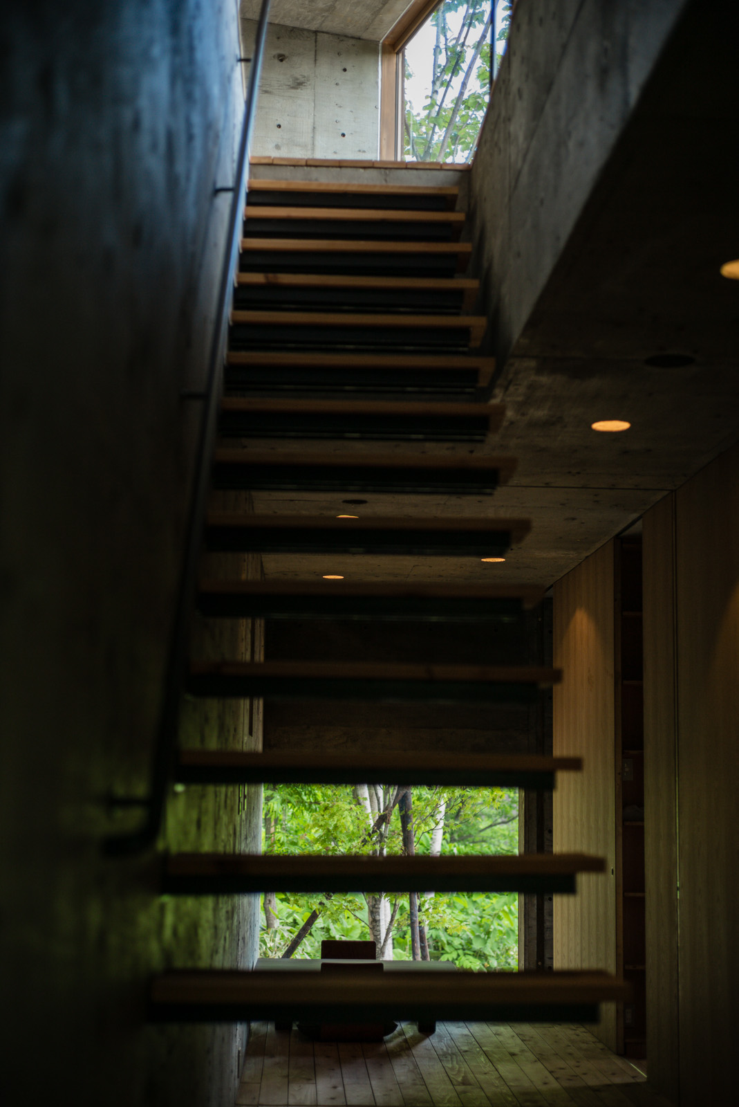 Denní zóna se nachází v poschodí, do něhož vede ocelové schodiště s dřevěnými nástupnicemi, které architekti upřednostnili před plným železobetonovým, čímž se prostor provzdušnil.