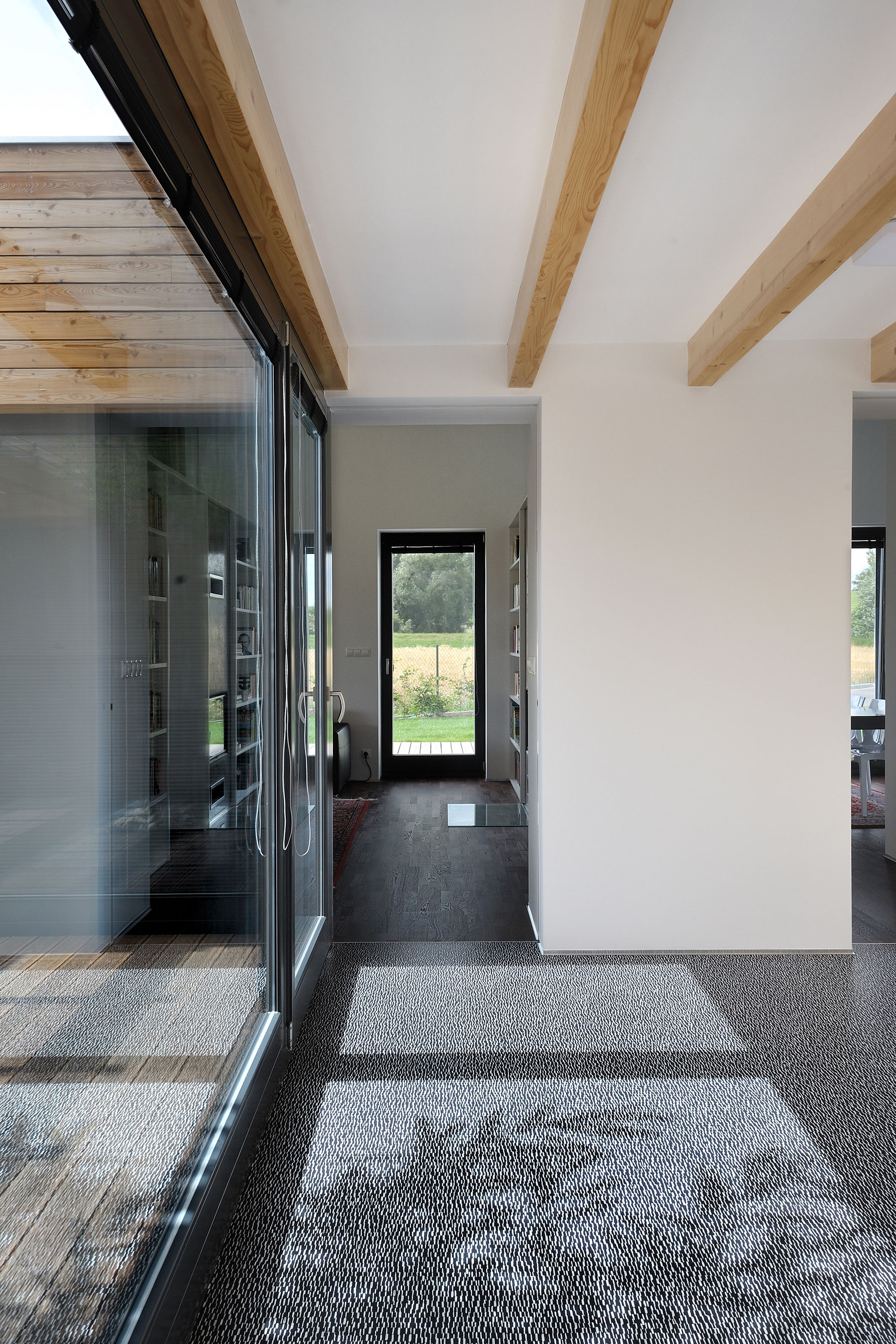Přístřešek pro automobil a zastropení společného obývacího prostoru mají konstrukci z lepených dřevěných vazníků.