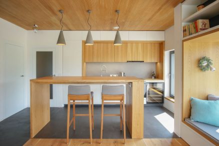 Hlavní obytná místnost je rozdělena na kuchyň s barem a relaxační zónu s velkou okenní sedací nikou.