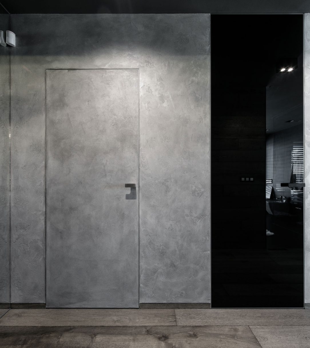 Penetrovaná MDF deska na dveřích MASTER DOOR nese na svém povrchu betonovou stěrku ze sousedící stěny.