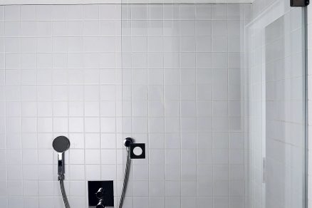 V koupelně je betonový strop kombinovaný s bílými obklady.