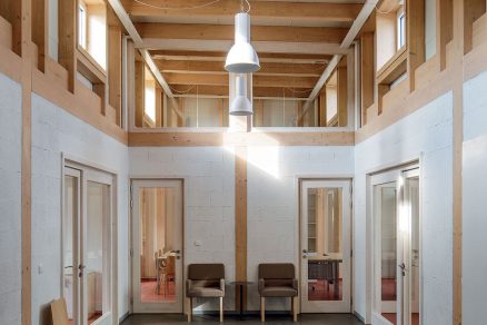 Jednoduchá architektura interiéru využívá dřevo bílou barvu a strukturu liaporových tvárnic.