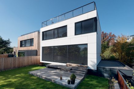 Bílý obklad EQUITONE tectiva dodává stavbě strohý ale elegantní vzhled. Koresponduje s minimalistickým konceptem domu.