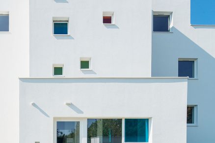 Východní fasáda do ulice je ozvláštněna barevnými akcenty čtvercových oken.