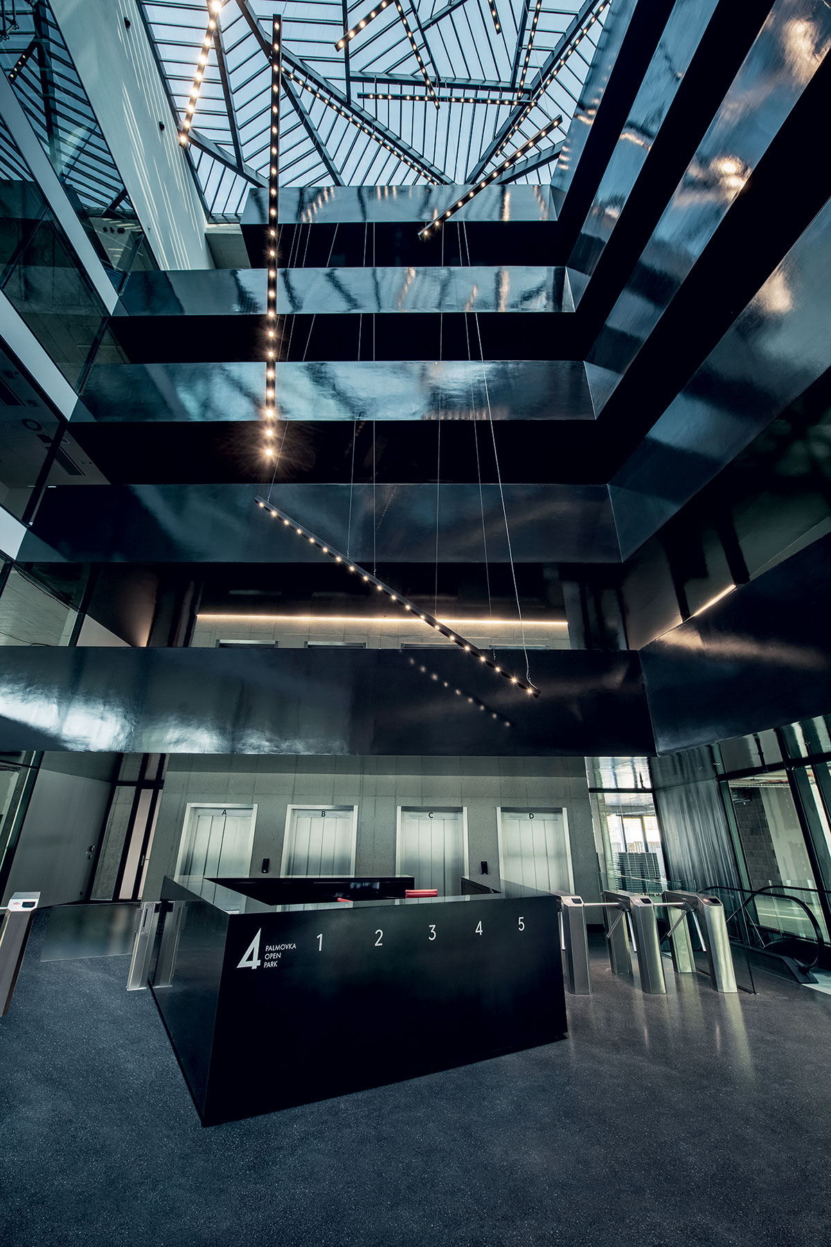 Do atria kancelářské budovy proniká světlo skrze prosklený strop.