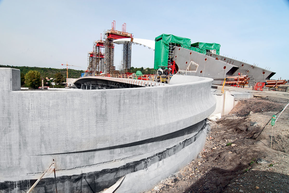 Zvláštní projekty vyžadují i zvláštní bednění vyráběné na míru. Efektní otisk lze zajistit například ohýbanými překližkovými latěmi. (Foto: pohledové betony realizované na Trojském mostě, Praha) 