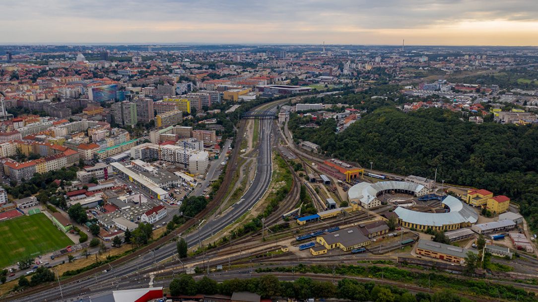 Pohled k Edenu. Původní trať Hostivař – Vršovice (vlevo), nové zaústění tratí Vršovice – Krč, odstavné nádraží jih a depo Praha (vpravo)