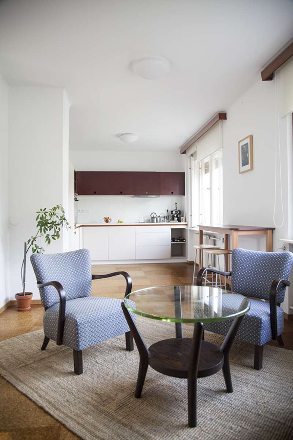 Prakticky a současně příjemně zařízený prostor obývacího pokoje a kuchyně propojuje barový stůl s roxorovými židlemi.