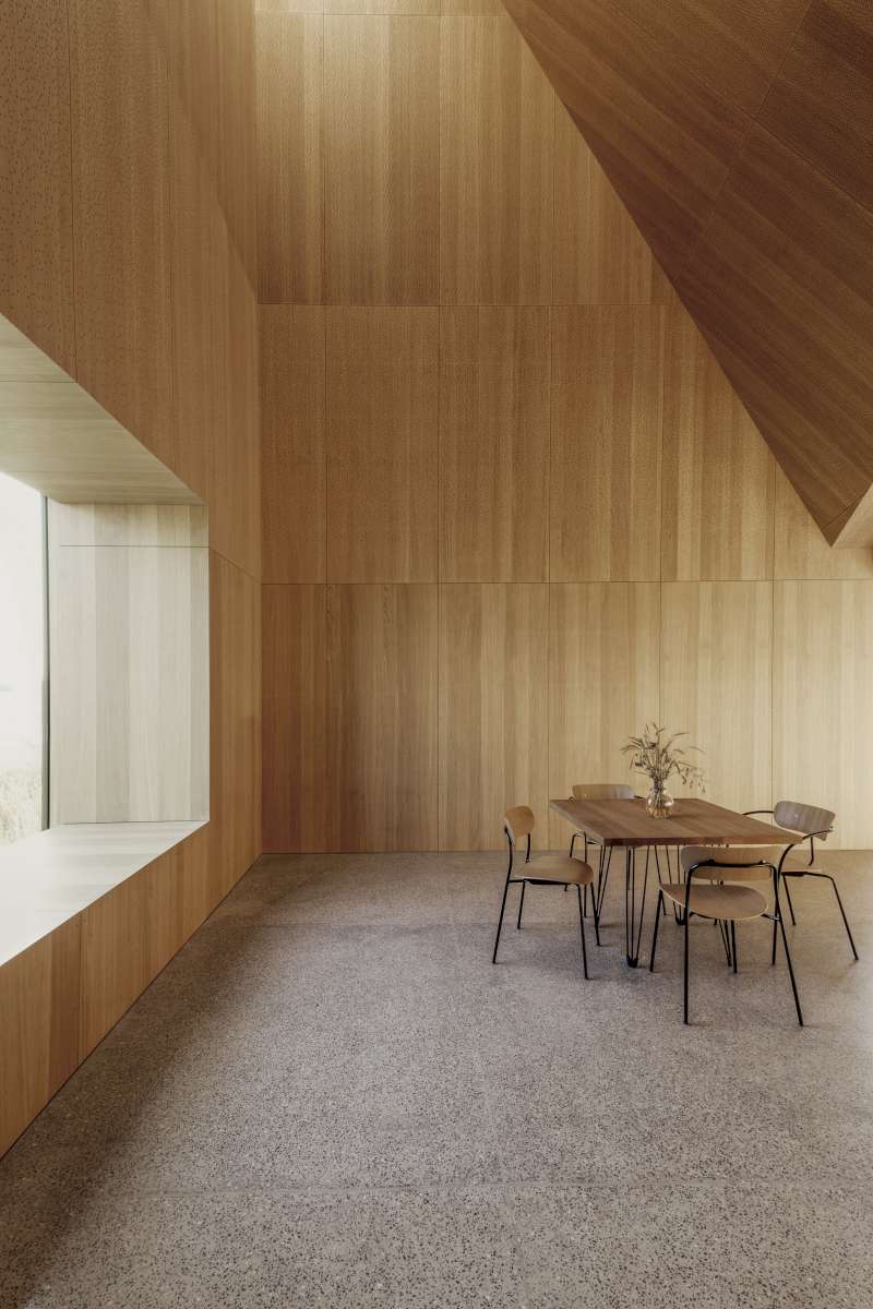 Interiér v tlumené tonalitě dřeva byl navržen jako přirozená součást okolních pšeničných polí.