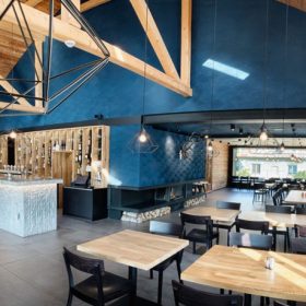 Tmavomodré štukové stěny ve spojení s bledým dřevem zajímavě dolaďují interiér restaurace.