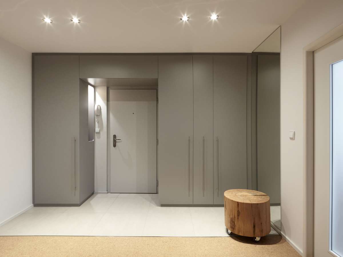 Převažujícím barvou v bytě je bílá kombinovaná se světle šedými odstíny na zabudovaných nábytkových prvcích. 