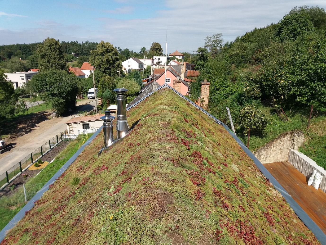 Šikmá zelená střecha ve sklonu 35° kopíruje uliční zástavbu historické obce Střílky. Šikmé zelené střechy se realizují s extenzivní vegetací.