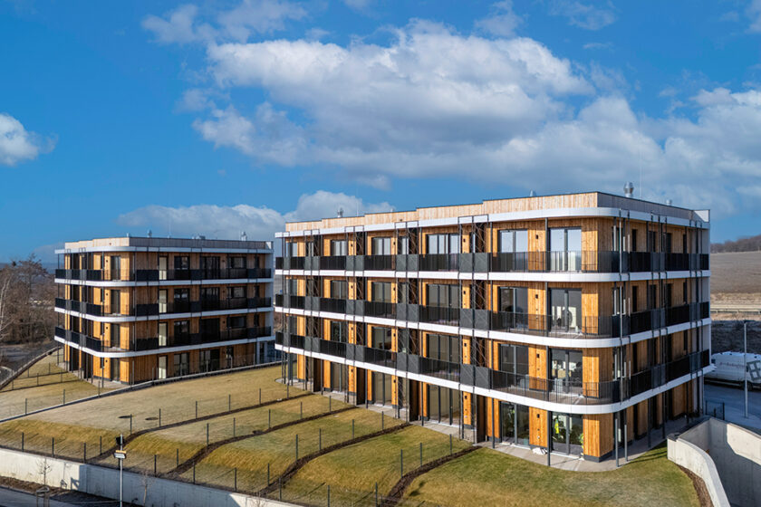Vícepodlažní dřevostavby Timber Praha s dřevěnou fasádou a moderní architekturou v lokalitě Praha-Řeporyje.