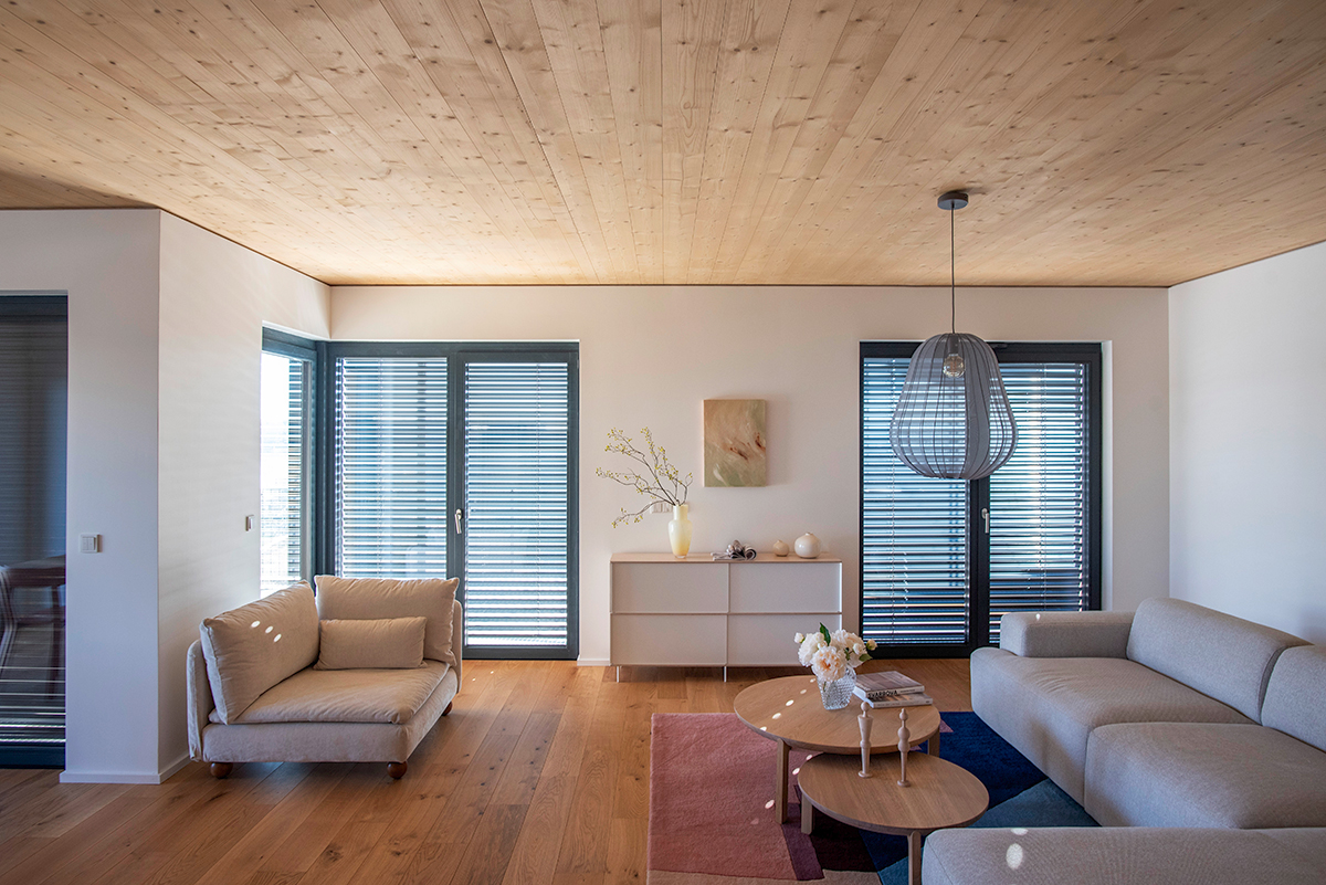 Světlý interiér bytu v Timber Praha s podlahovým vytápěním REHAU a přírodními materiály.
