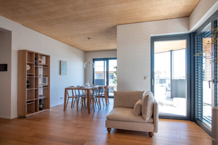 Prosvětlený obývací prostor s jídelním koutem ve vícepodlažní dřevostavbě Timber Praha.