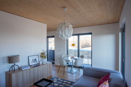 Prosvětlený obývací prostor s jídelním koutem ve vícepodlažní dřevostavbě Timber Praha.