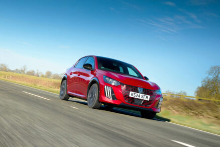Přední pohled na Peugeot E-208 v pohybu