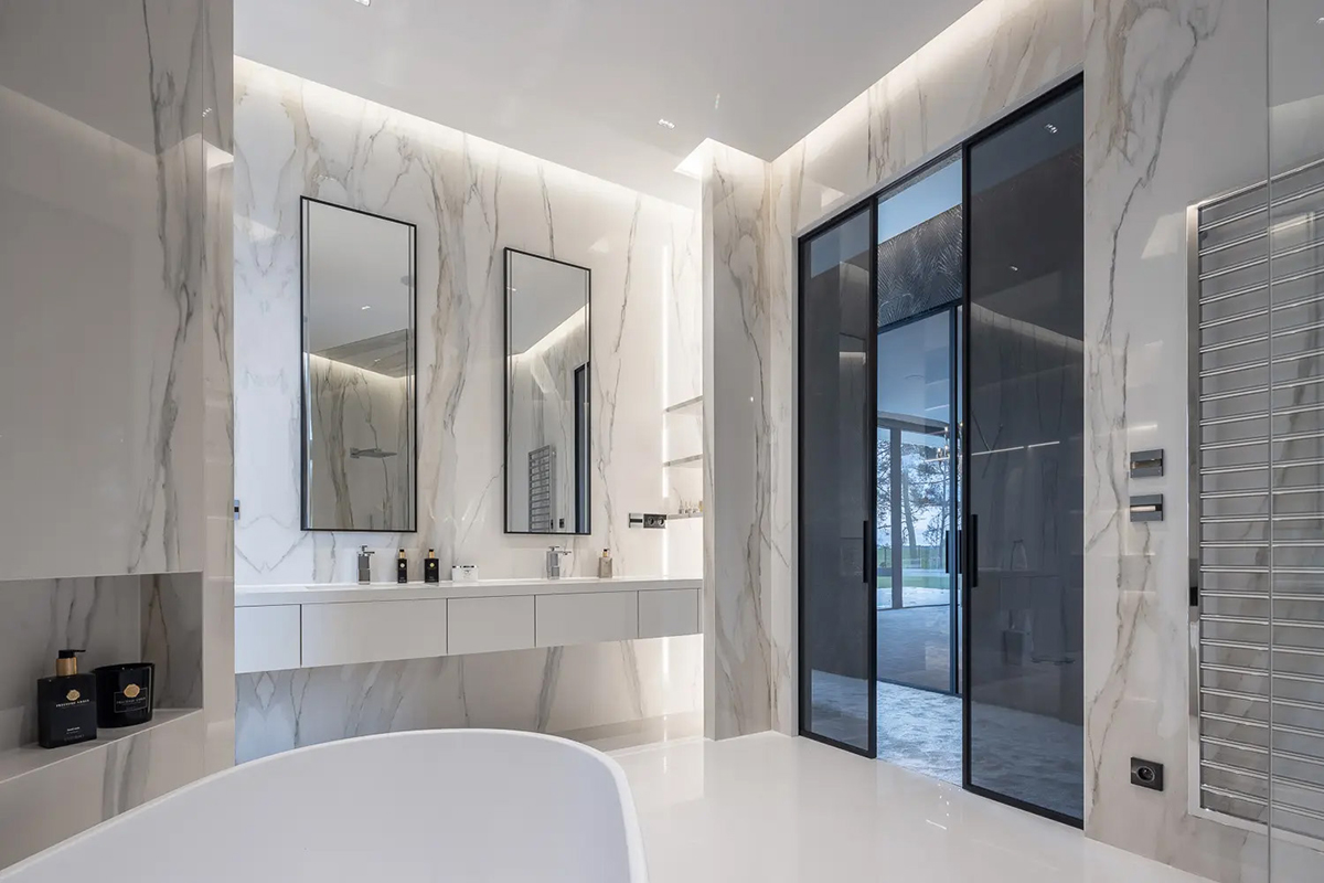 Luxusní koupelna v interiéru vily Regent s mramorovými obklady a designovými dveřmi