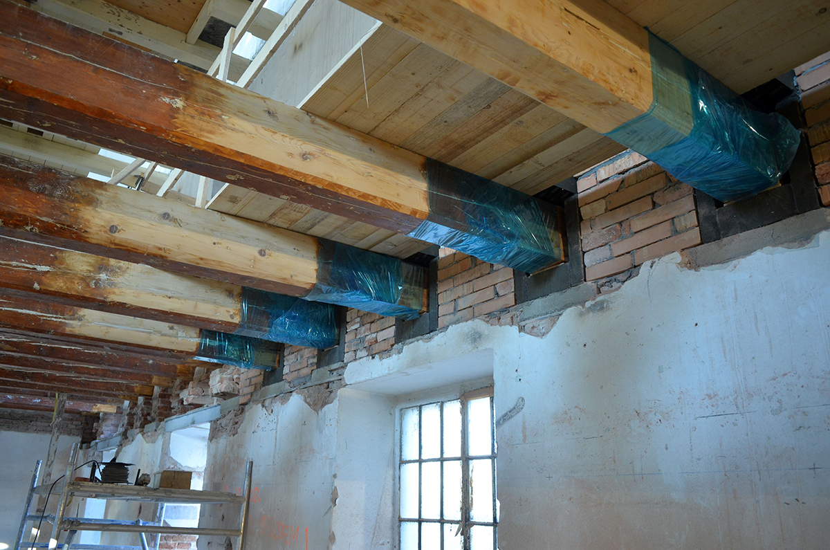 Renovace stropní konstrukce s odkrytými trámy a původním zdivem v Automatických mlýnech