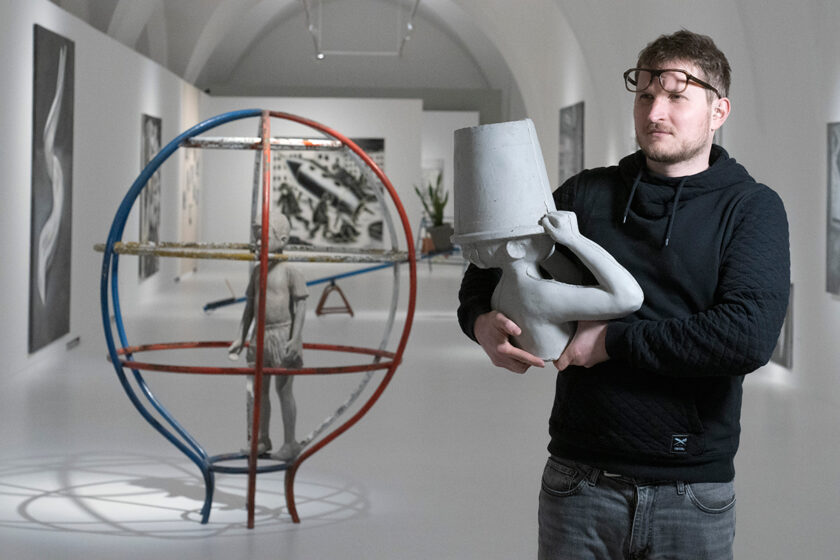Sochař Jakub Janovský s betonovou sochou dítěte na výstavě svých děl inspirovaných sídlištní estetikou