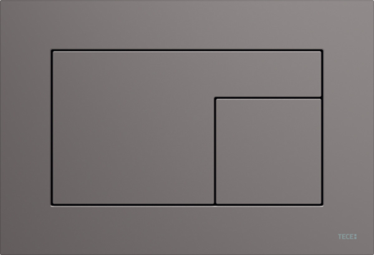 Šedé minimalistické tlačítko pro toaletu na hladkém matném povrchu