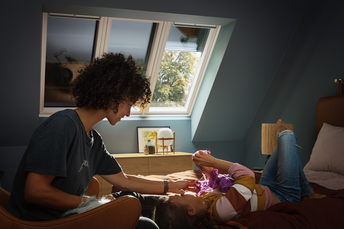 Interiér ložnice se střešními okny VELUX se stínicí technikou pro příjemné klima