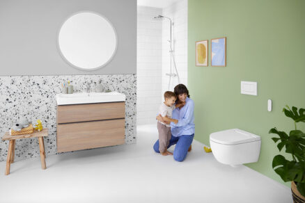Rodina v koupelně se sprchovacím WC Geberit AquaClean Alba na zelené stěně