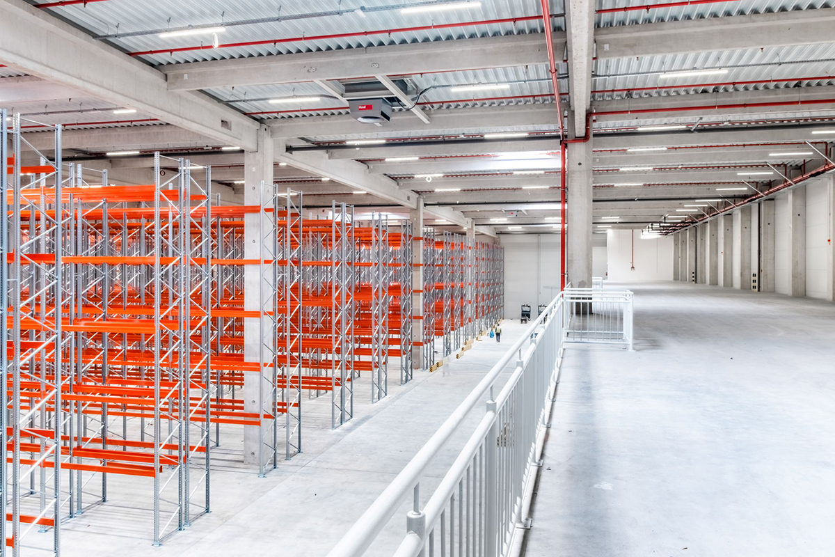 Interiér moderní logistické haly LOGspot Logatec s ocelovými regály a úsporným LED osvětlením