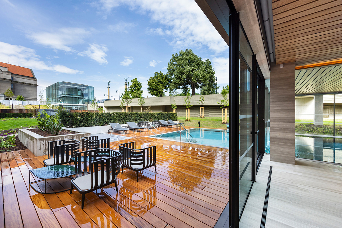 Venkovní terasa a bazén wellness centra hotelu Fairmont obklopená moderní architekturou a zelení