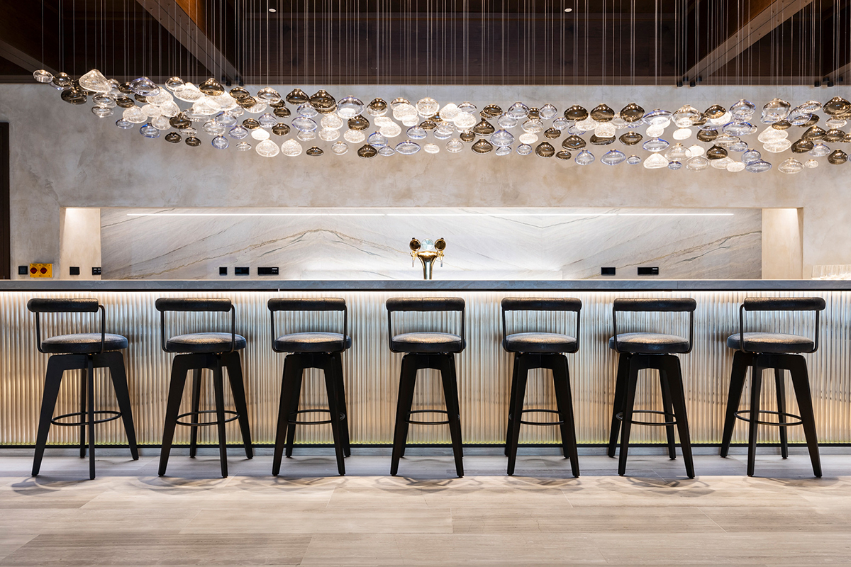 Stylový hotelový bar s designovým osvětlením a mramorovým obkladem