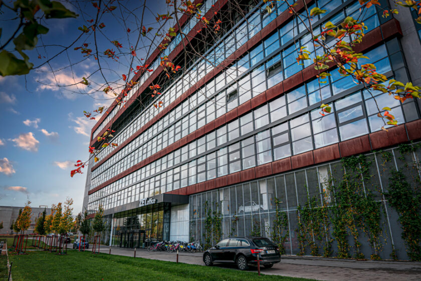 Moderní kancelářská budova s rozsáhlou prosklenou fasádou AVG a prvky udržitelné architektury.