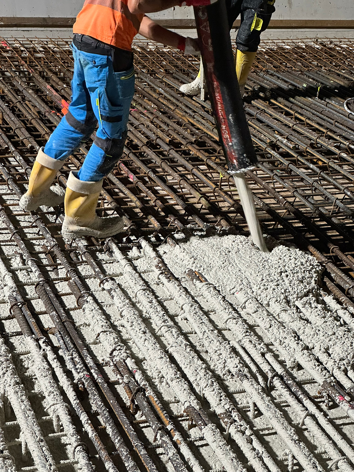 Detailní pohled na lití bílého betonu do armované konstrukce Dvoreckého mostu