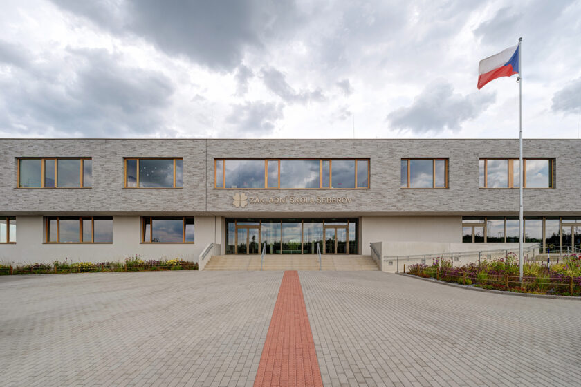 Moderní školní budova s cihelnou fasádou a minimalistickým exteriérem v Šeberově