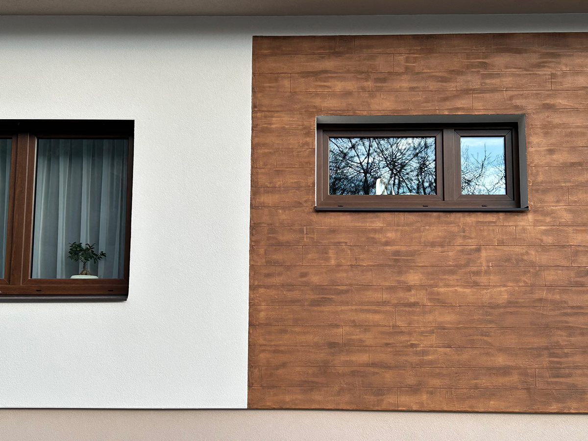 Detail fasády s kombinací bílé omítky a kreativního nátěru v imitaci dřeva