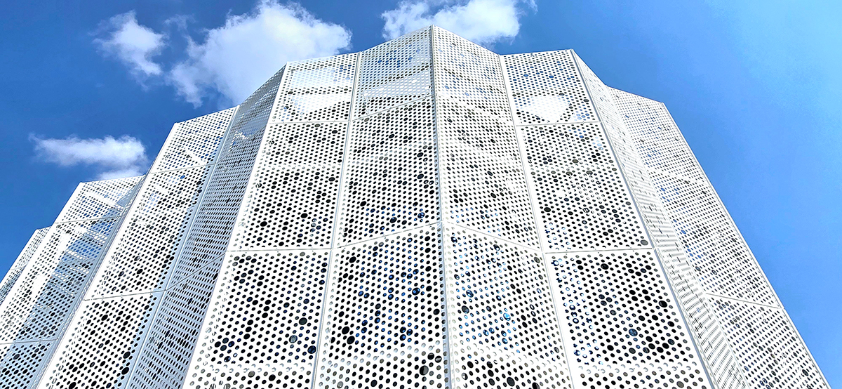 Fasáda moderní budovy pokrytá děrovanými plechy AVG Metal s geometrickým designem