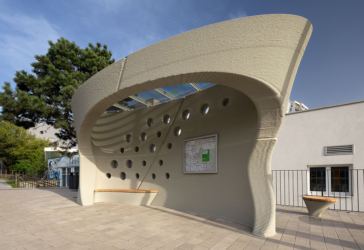 3D tištěná autobusová zastávka s organickými tvary a otvory ve stěně