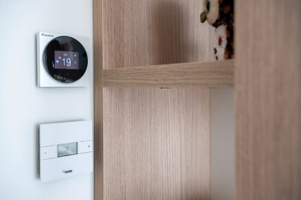 Detailní pohled na nástěnný termostat REHAU a Daikin pro řízení podlahového vytápění