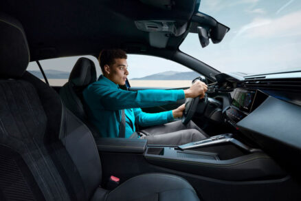 Řidič za volantem vozu Peugeot 408, pohled na kokpit a moderní technologie palubní desky.