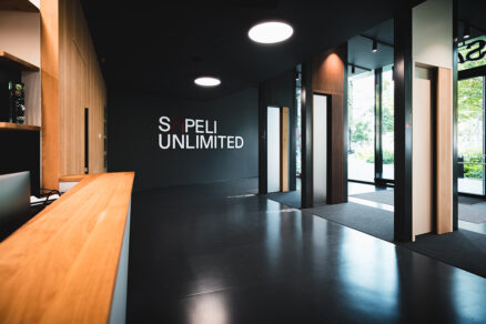 Vstupní prostor showroomu SAPELI Unlimited s vystavenými dveřmi a firemním logem na zdi
