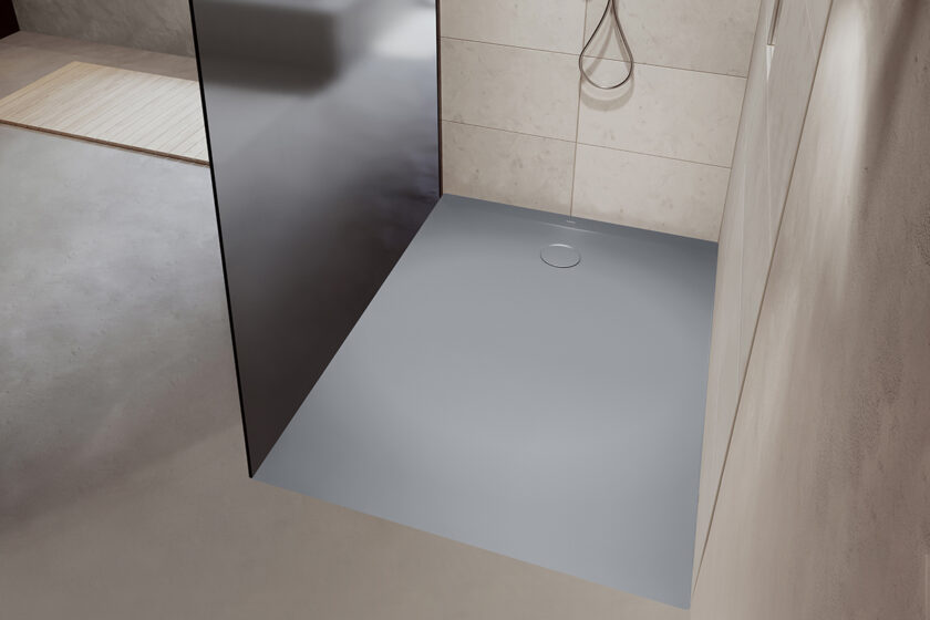 Moderní koupelna s minimalistickou sprchovou vaničkou v šedé barvě s bezbariérovým vstupem.