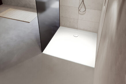 Elegantní bílá sprchová vanička instalovaná v moderní koupelně s minimalistickým vzhledem.
