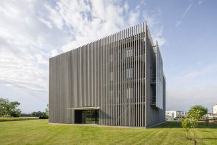 Architektonický vzhled novostavby je do značné míry definován předsunutou dřevěnou fasádou s lamelami.