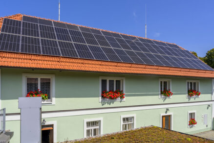 Střecha domu s instalovanými fotovoltaickými panely pro výrobu solární energie.