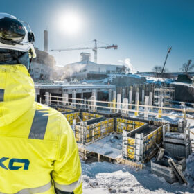 Staveniště v zimních podmínkách s použitím bednění Doka a dohledem pracovníka v ochranném oděvu.