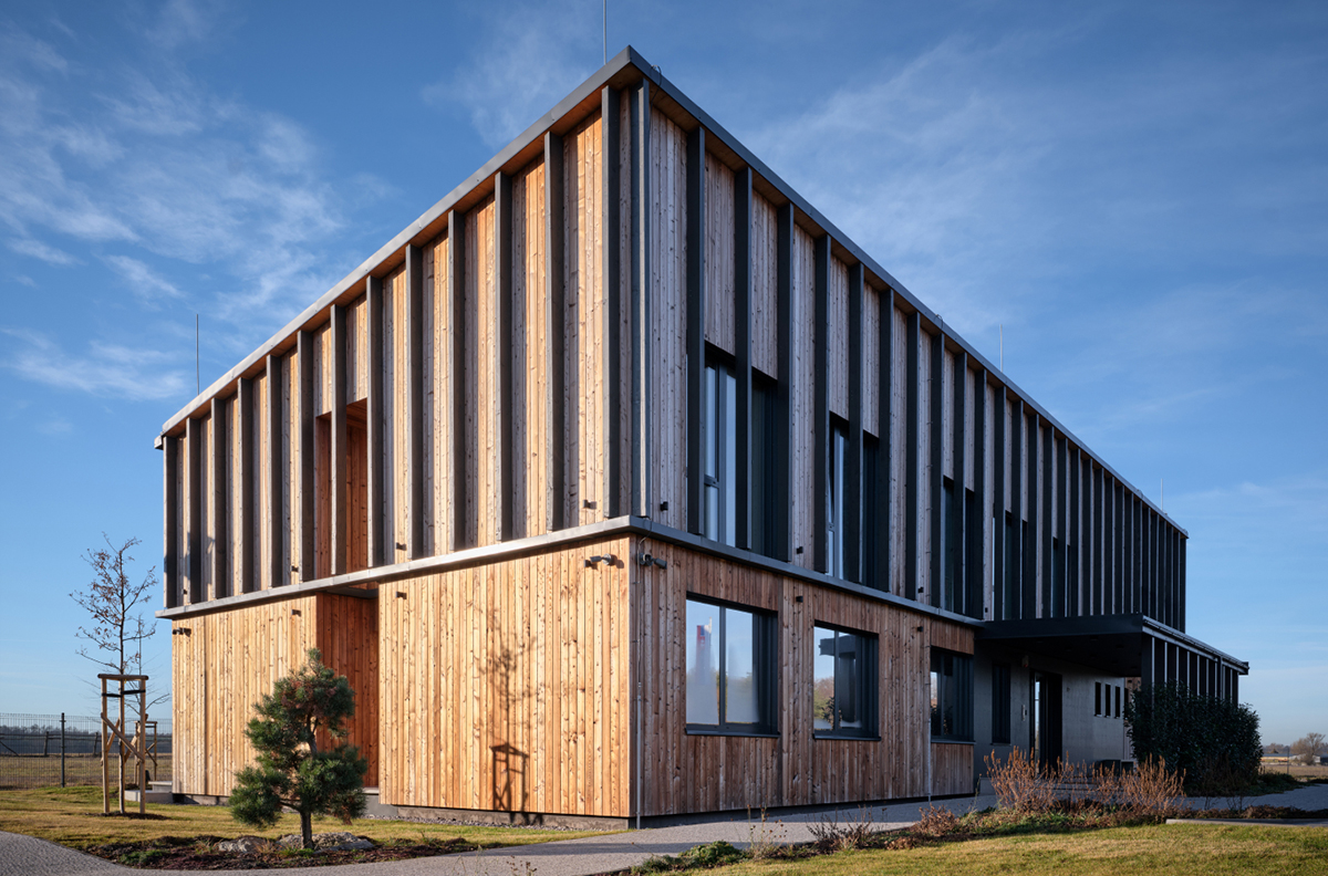 Moderní administrativní budova s vertikálním obkladem z dřevěných a vláknocementových panelů