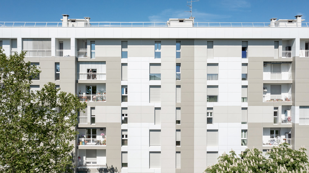 Revitalizovaný panelový dům s novou fasádou z vláknocementových panelů v neutrálních tónech