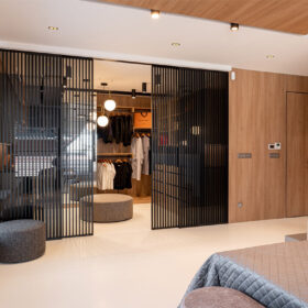 Posuvné dveře IDEALINE s černými lamelami pro oddělení šatny v ložnici