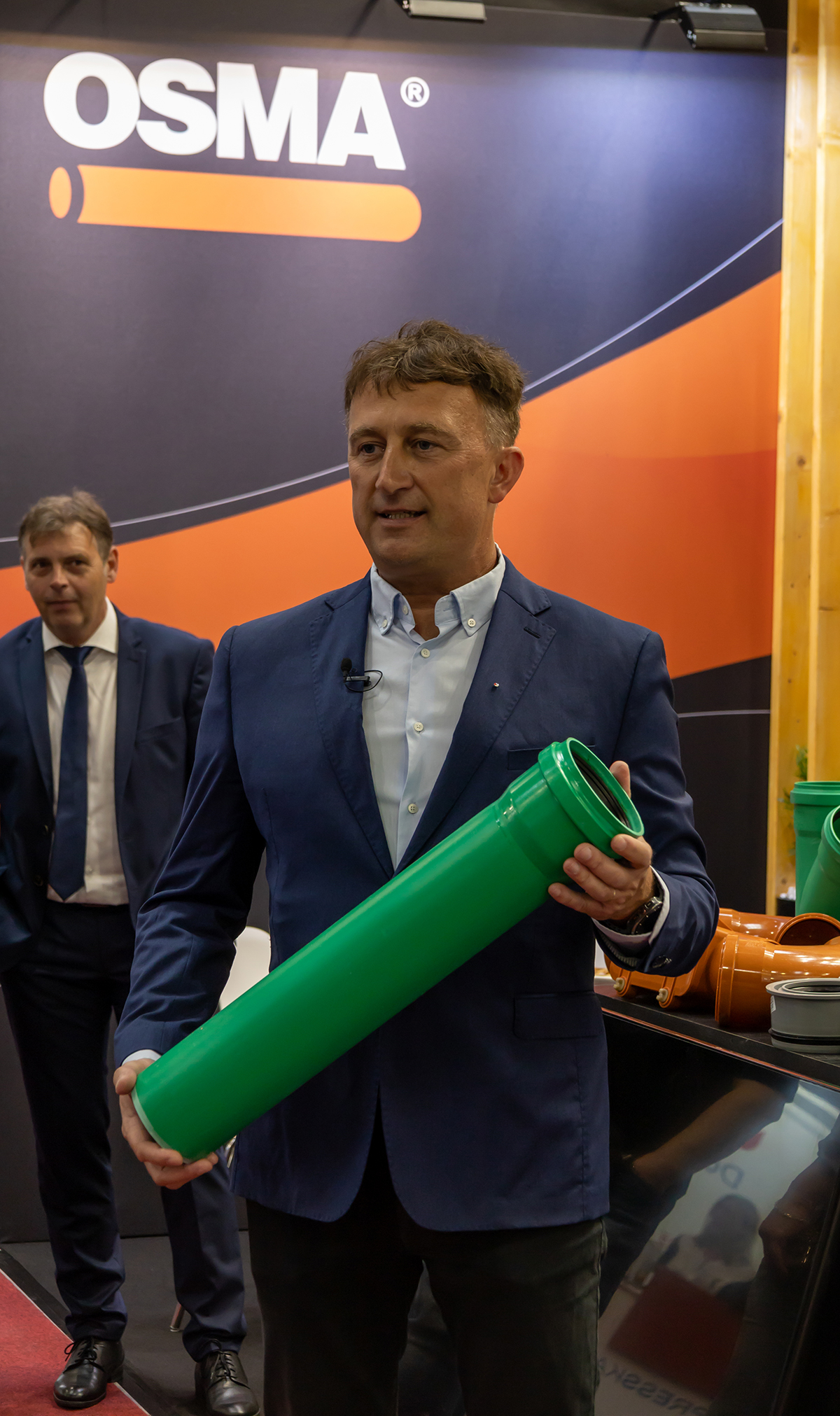 Zástupce firmy OSMA drží zelenou kanalizační trubku s elektrofúzní spojkou