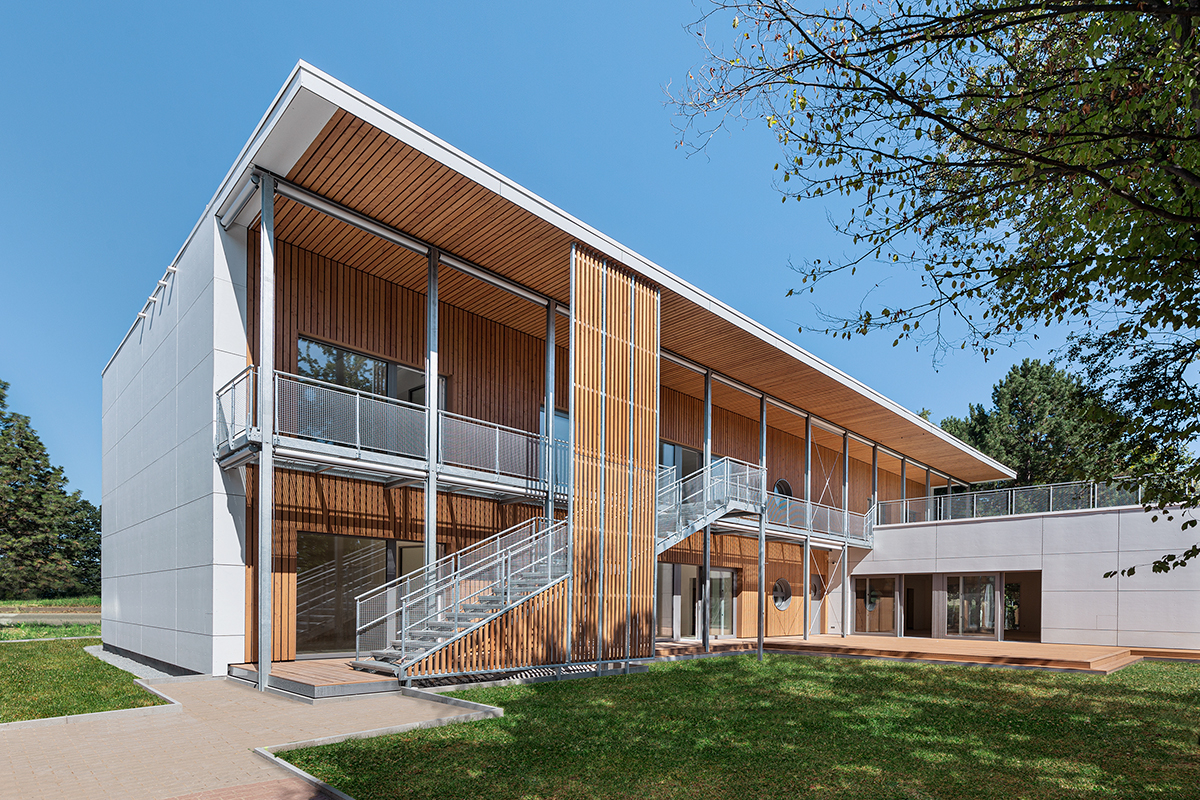 Dvoupatrový veřejný objekt s kombinací vláknocementových fasád a dřevěných lamel